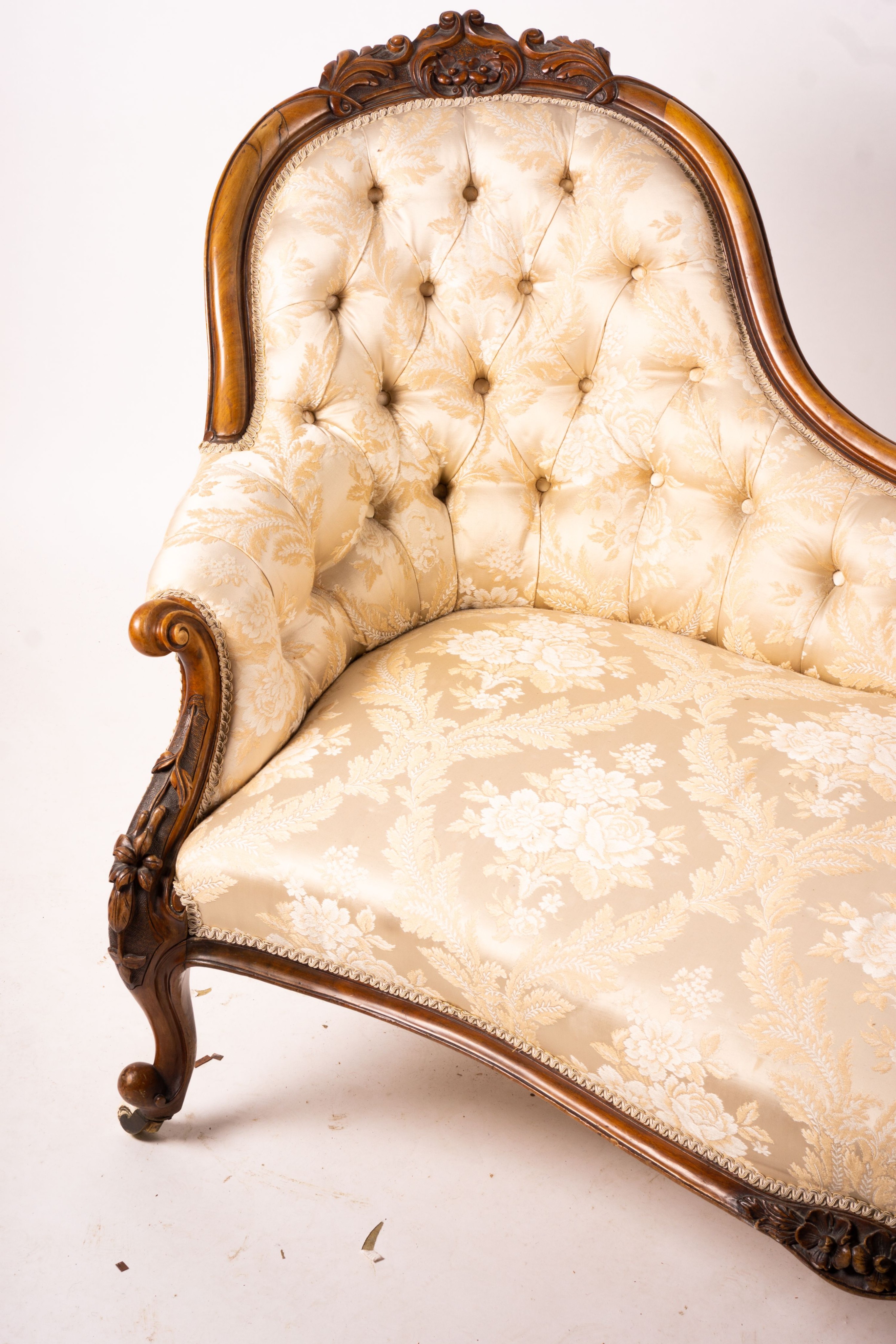 A late Victorian carved walnut three piece salon suite, comprising chaise longue, open armchair and nursing chair